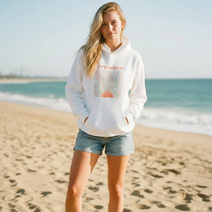 De witte Emma hoodie met sweatshirt-comfort, gedragen op het strand bij zonsondergang